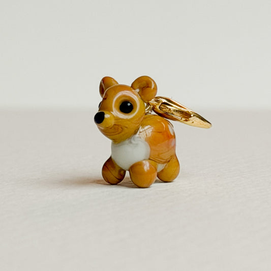 Glass deer charm with gold clasp on a white background