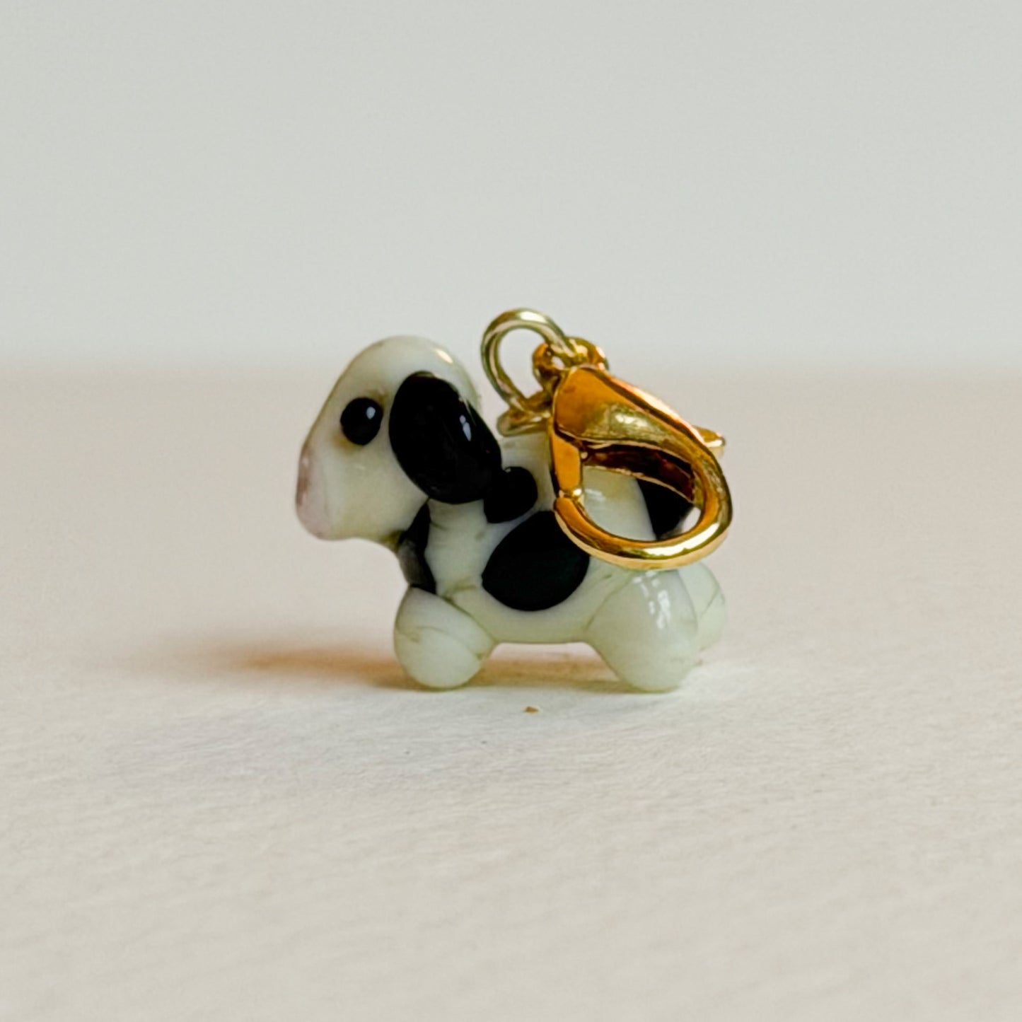 Cow-shaped charm with gold clasp on a white background